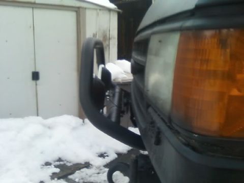 1989 Ford Bronco - A 1989 Ford Bronco's front end is visible, equipped with a light bar and surrounded by snow.
