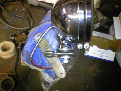1989 Ford Bronco - A chrome headlight assembly is shown, likely an aftermarket part, with its mounting hardware and wiring visible.