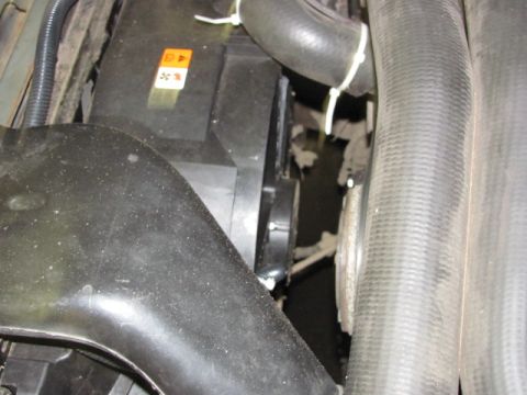 1989 Ford Bronco - Close-up view of an electric fan and radiator hoses, with a warning sticker visible.
