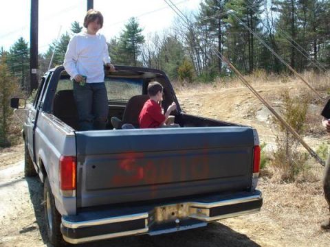 1989 Ford Bronco - A gray pickup truck with red graffiti on its tailgate is seen from the rear, with two boys in the bed.