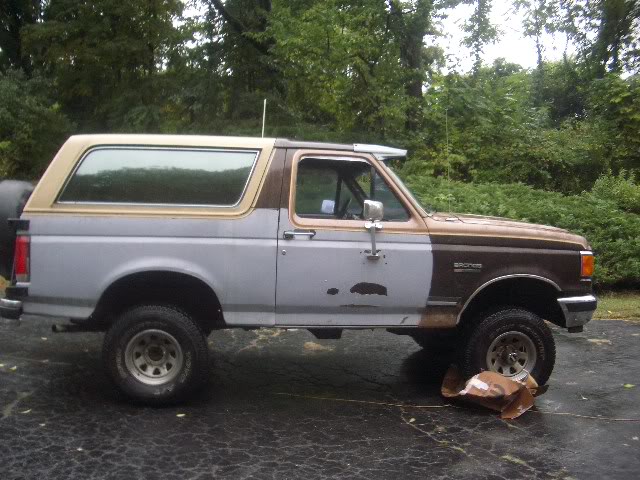 Ford Bronco with two-tone paint, primer on the front fender and door, and a tan roof