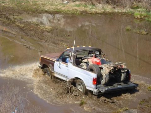 1989 Ford Bronco - This 1989 Ford Bronco navigates a muddy terrain with an ATV loaded in its bed.