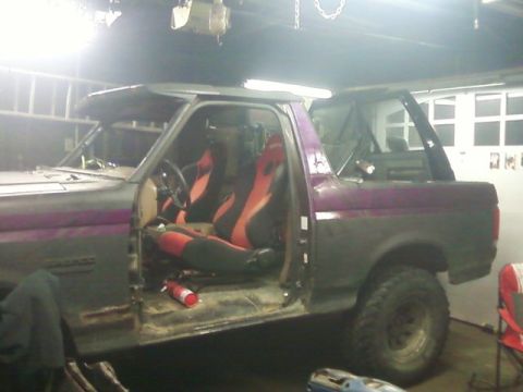 1989 Ford Bronco - This Ford Bronco, likely from the late 1980s, is undergoing modifications with racing seats and a visible fire extinguisher.