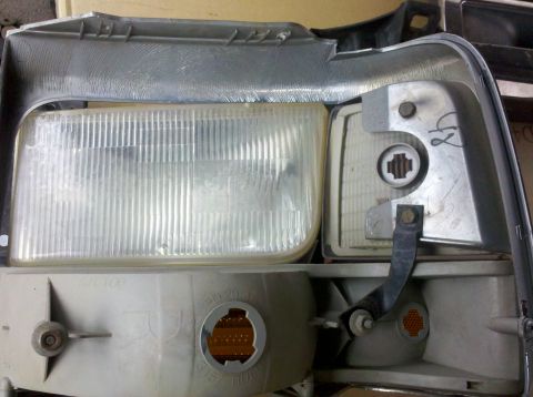 1995 Ford Bronco - Close-up of a vehicle's headlight assembly, revealing its internal components and textured lens.