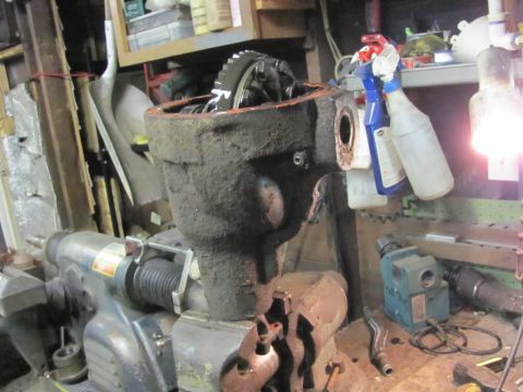 1989 Ford Bronco - A differential housing, likely for a Ford Bronco, is secured in a vise for work in a garage setting.
