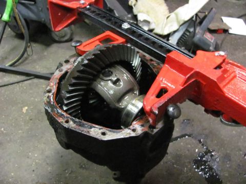 1989 Ford Bronco - Differential assembly with gears held by a red tool on a workshop floor.