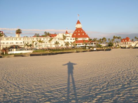 1971 Ford Ranchero - A beach scene with a large hotel in the background and a person's shadow on the sand.