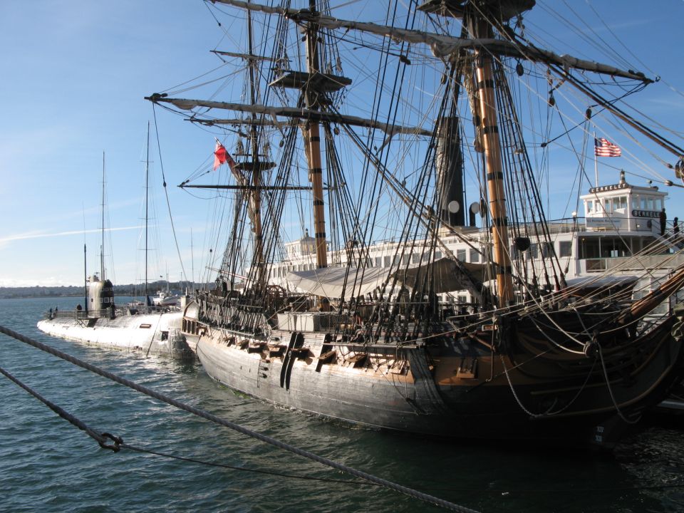 Tall ship moored beside the ferry Berkeley and a submarine at a harbor maritime museum