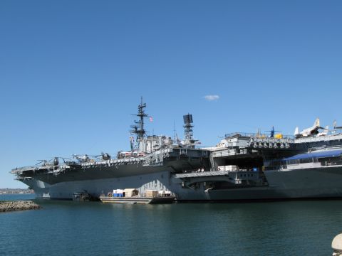 1971 Ford Ranchero - A large aircraft carrier is moored in the water under a clear blue sky.