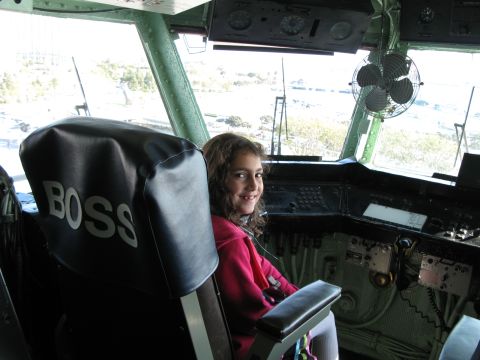 1971 Ford Ranchero - Young girl sits in the pilot's seat of a cockpit, with 'BOSS' lettering on the headrest.
