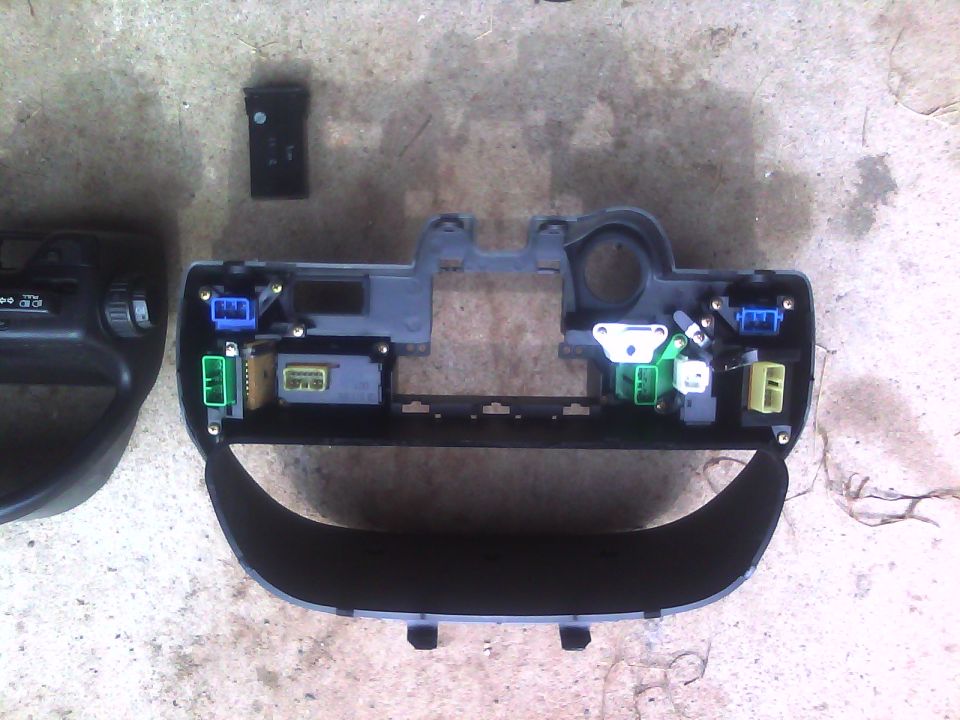 Dashboard trim piece with blue, green, and yellow electrical connectors and wiring