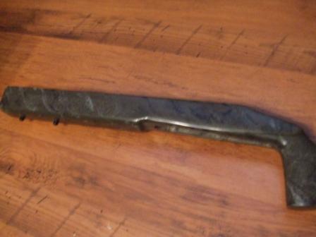1996 Ford Bronco - A dark, possibly metal, vehicle component rests on a wooden surface.