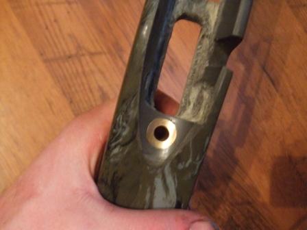 1996 Ford Bronco - A hand holds a vehicle part with a marbled finish and a brass accent.