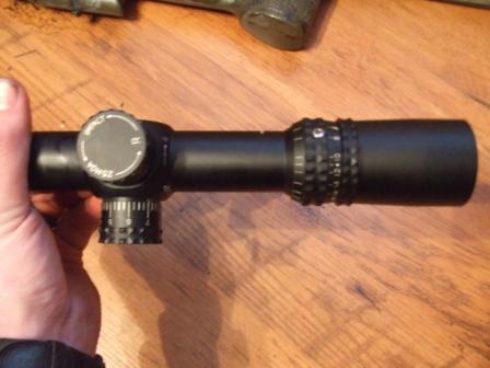 1996 Ford Bronco - A rifle scope is held in hand, showing adjustment turrets and markings.