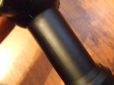 1996 Ford Bronco - A close-up view of a black cylindrical part against a wooden background.