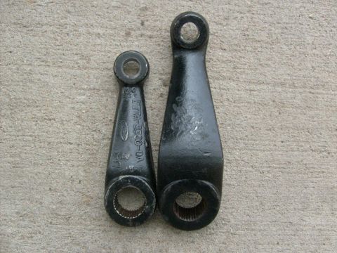 1994 Ford Bronco - Two steering linkage arms are shown, one smaller than the other, resting on a concrete surface.