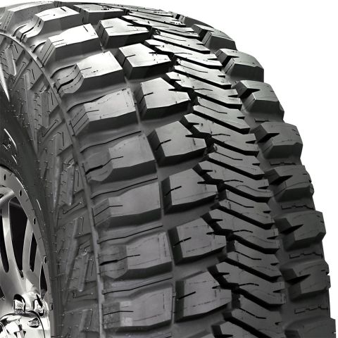 1995 Ford Bronco - Close-up of an aggressive mud-terrain tire tread with large blocky lugs, mounted on a chrome/polished multi-spoke wheel partially visible a…