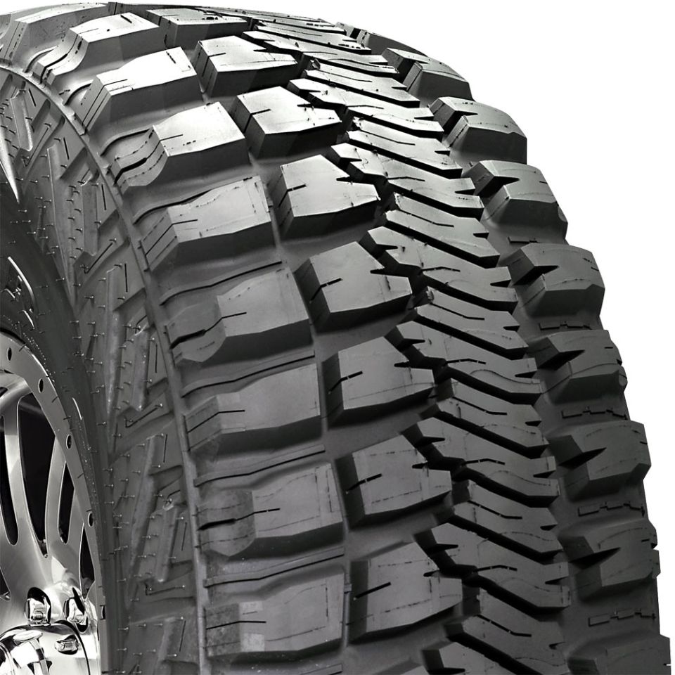 Close-up of aggressive mud-terrain tire tread on a chrome wheel