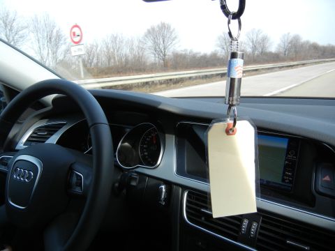 2010 Audi A4 - The interior of an Audi shows the steering wheel, dashboard, and navigation system, with a blank tag hanging from the rearview mirror.