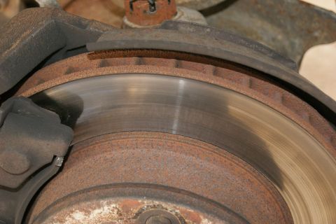 1978 Ford Bronco - Close-up view of a corroded brake rotor and caliper, showing signs of age and use.