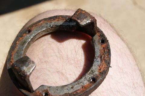 1978 Ford Bronco - Close-up of a corroded metal component, possibly a bracket or adapter, against skin.
