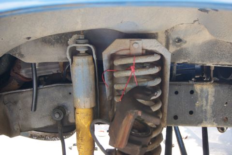 1978 Ford Bronco - Close-up view of the front suspension system, showing the coil spring and shock absorber.