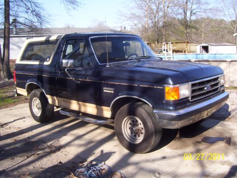 1990 Ford Bronco - This 1990 Ford Bronco is parked in a driveway with a swimming pool in the background.