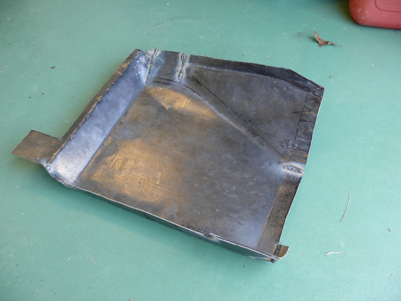Metal floor pan with cut lines and welds, possibly for a car