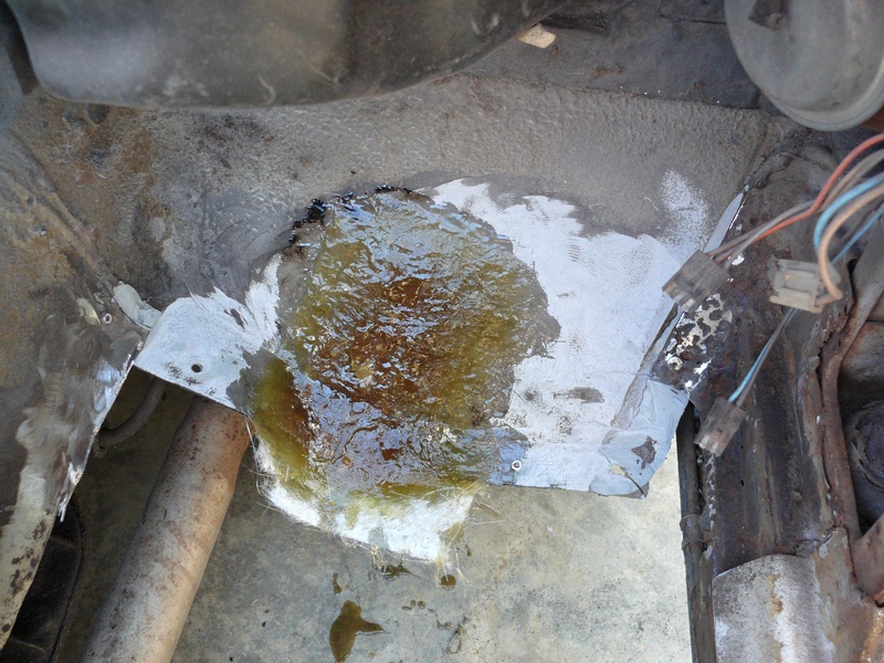 Underbody damage with fluid leak and exposed wiring. SuperMotors.net logo visible