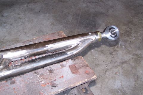 2000 Ford F-150 - A custom suspension linkage with a heim joint is shown resting on a workbench.