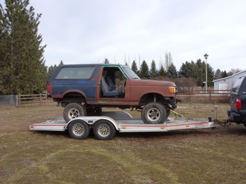 1988 Ford Bronco - This 1988 Ford Bronco is being transported on a trailer, showing its modified body and primer finish.