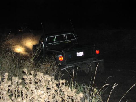 1981 Ford Bronco - A pickup truck navigates a dark, off-road path with its headlights illuminating the way.