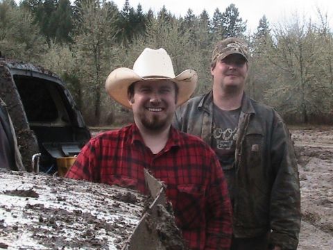 1978 Ford Bronco - Two men pose for a photo in a muddy outdoor environment with trees in the background.
