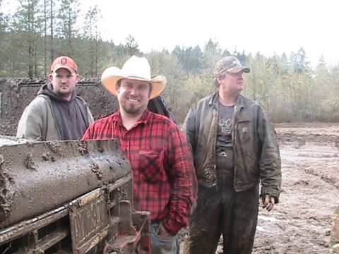 1978 Ford Bronco - Three men pose for a photo in a muddy outdoor environment, with trees in the background.