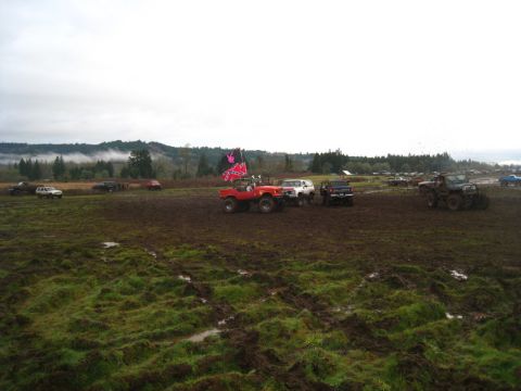 1978 Ford Bronco - Multiple off-road vehicles navigate a muddy terrain under an overcast sky.