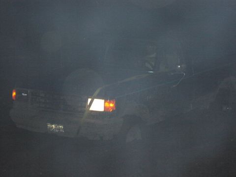 1981 Ford Bronco - A 1981 Ford Bronco is seen from the front in a dimly lit environment, possibly during nighttime or in a dark setting.