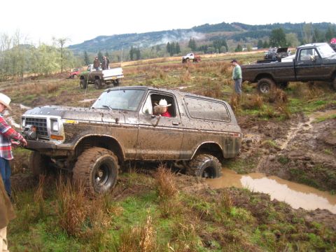 1978 Ford Bronco - 1978 Ford Bronco navigating a muddy off-road course, with other vehicles present.