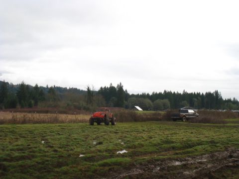 1978 Ford Bronco - Two vehicles are in a muddy field under an overcast sky.