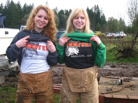 1978 Ford Bronco - Two women proudly display their Hooters t-shirts, one advertising Warner Robins, GA, and the other Macon, GA, in a muddy outdoor setting.