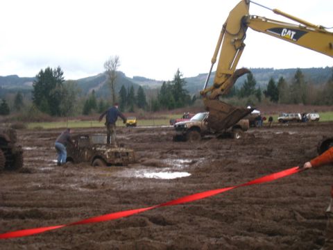 1978 Ford Bronco - Mud bog event with multiple vehicles stuck in the mud, an excavator, and spectators.