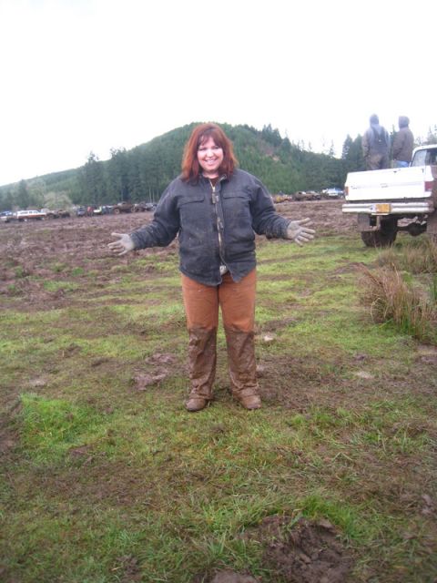 1978 Ford Bronco - A woman stands in a muddy field with several trucks visible in the background.