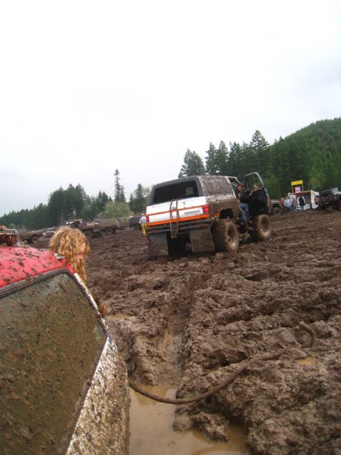 1978 Ford Bronco - Several vehicles are bogged down in thick mud during an off-road event.