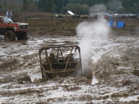 1978 Ford Bronco - An off-road buggy is stuck deep in the mud, with steam rising from its engine compartment.