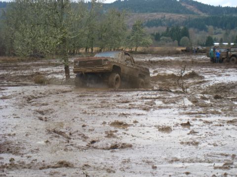 1978 Ford Bronco - Off-road truck struggles through deep mud during an event.
