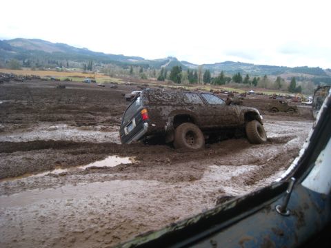 1978 Ford Bronco - Multiple vehicles are stuck in deep mud during an off-road event.