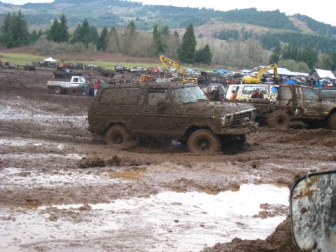 1978 Ford Bronco - Muddy 1978 Ford Bronco bogged down in a mud pit with other vehicles around.