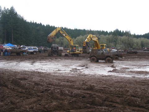 1978 Ford Bronco - Excavators and off-road vehicles are active in a muddy terrain, with spectators observing the scene.