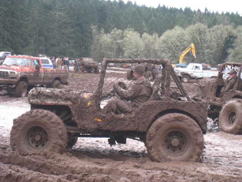Mud-covered off-road vehicle with driver in a muddy field