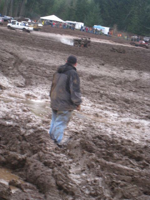 1978 Ford Bronco - ATVs churn up mud at an off-road event with spectators gathered.