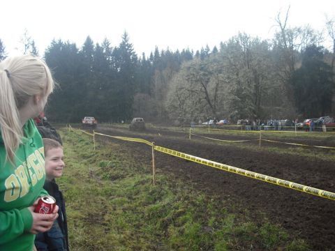 1978 Ford Bronco - Spectators observe a muddy off-road race event with multiple vehicles navigating the course.